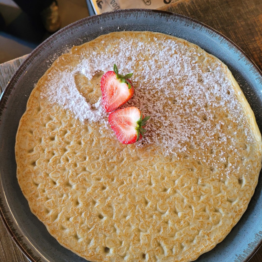 Pannenkoek met poedersuiker in hartvorm en aardbeien