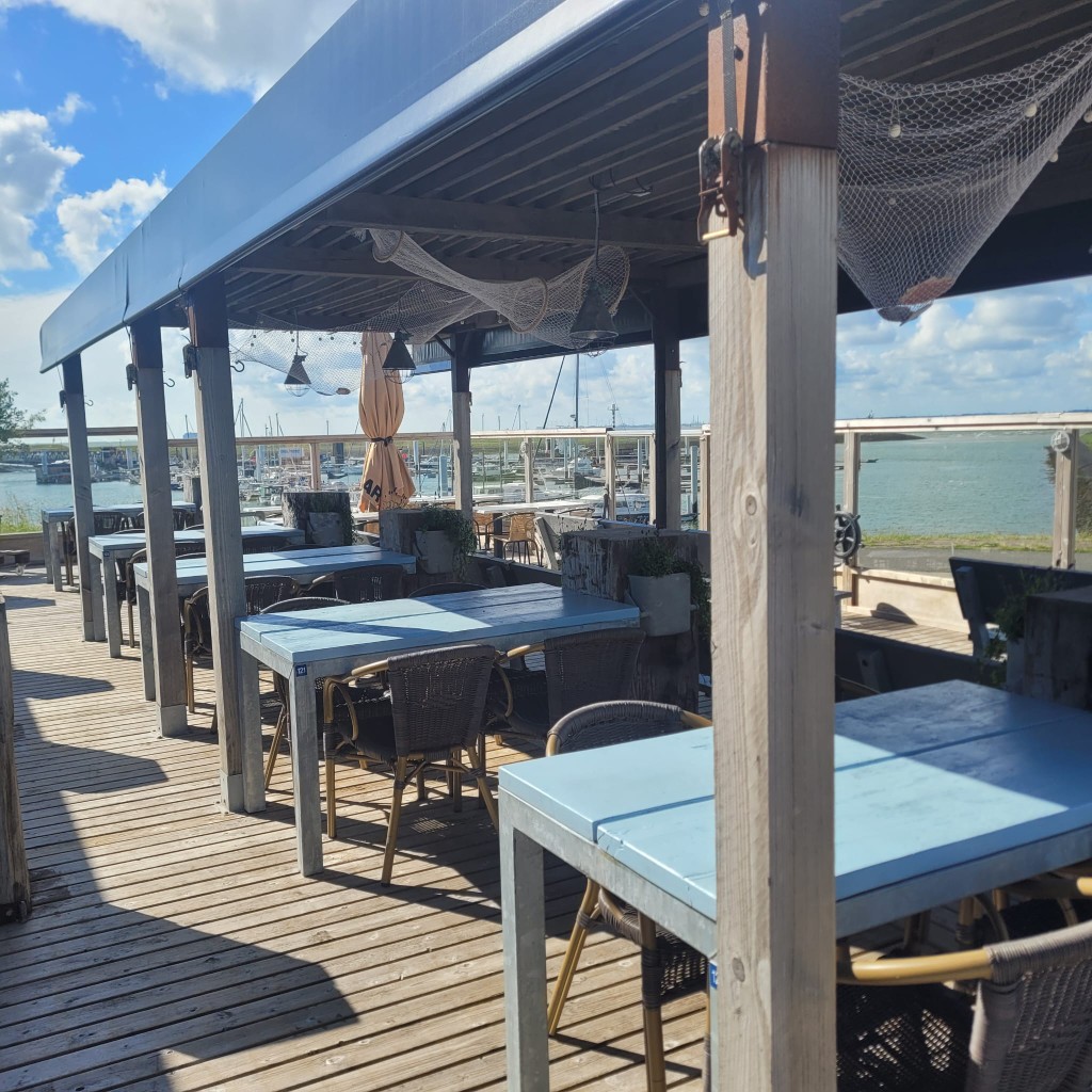Terras onder een luifel met uitzicht op de jachthaven