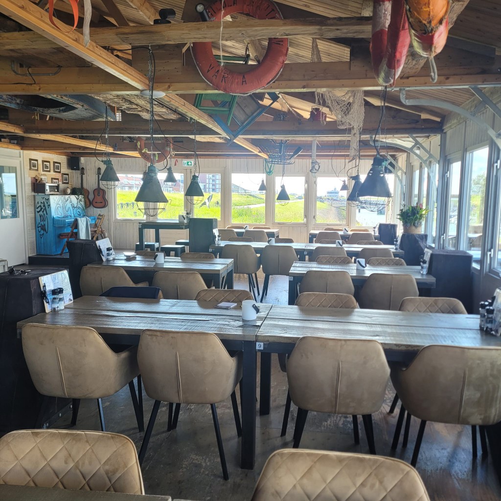 Sfeervolle eetzaal van FoodJutters met nautisch interieur en uitzicht naar buiten